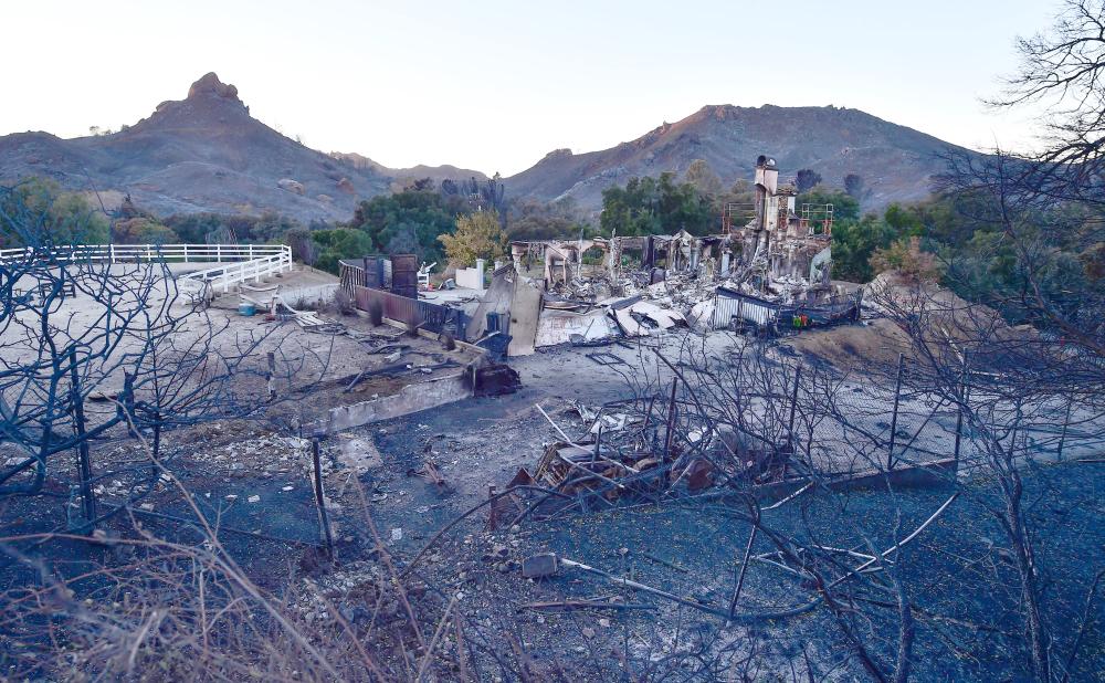 


The remnants of a home destroyed in the Woolsey fire are seen along Mulholland Highway in the hills above Malibu, California, on Monday. — AFP