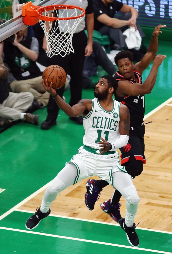 Kyrie Irving No. 11 of the Boston Celtics drives to the basket against Kyle Lowry No. 7 of the Toronto Raptors during the first half at TD Garden on Friday in Boston, Massachusetts. — AFP