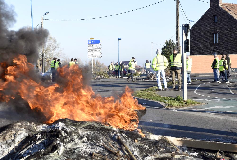 


Demonstrators of the Yellow Vests movement (Gilets Jaunes) stand by a fire on Sunday on a roundabout in Douchy-les-Mines, near Valenciennes, northern France, a day after a nationwide protest against high fuel prices. — AFP