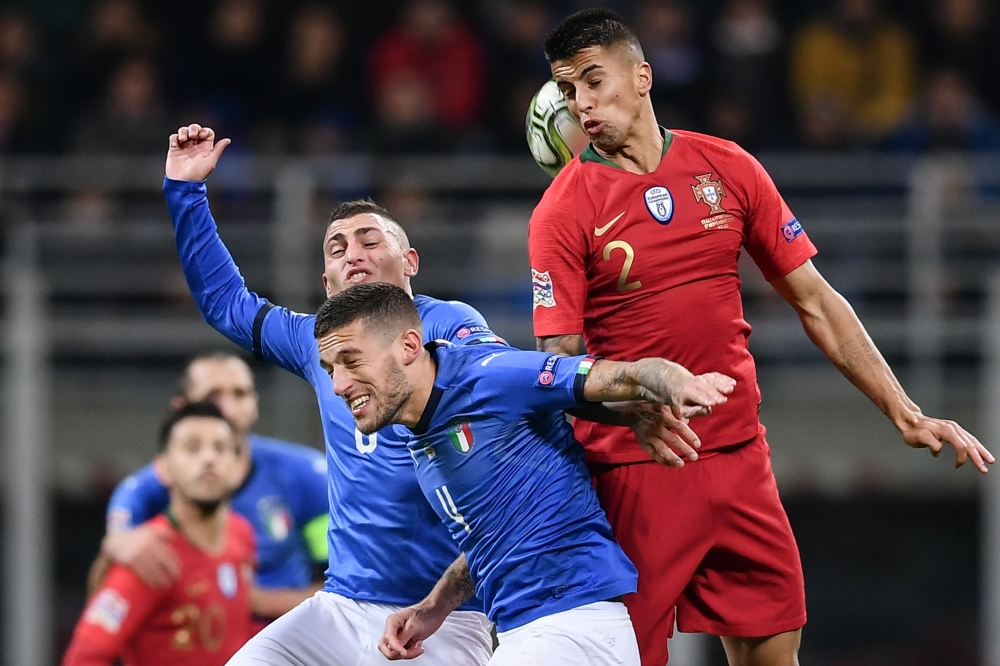 (From L) Italy's midfielder Marco Verratti, Italy's defender Cristiano Biraghi and Portugal's defender Joao Cancelo go for a header during the UEFA Nations League Group 3 football match at the San Siro Stadium in Milan on Saturday. — AFP