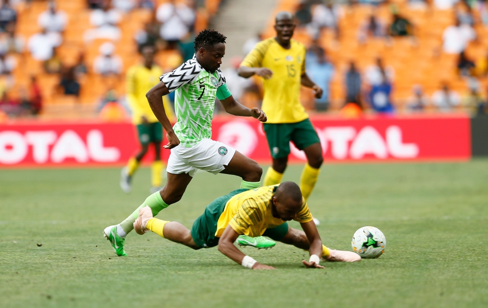 South Africa's Tiyani Mabunda is tackled by Nigeria's captain Ahmed Musa during the African Cup of Nations qualifier match between South Africa and Nigeria on Saturday at Soccer City Stadium in Johannesburg, South Africa. — AFP