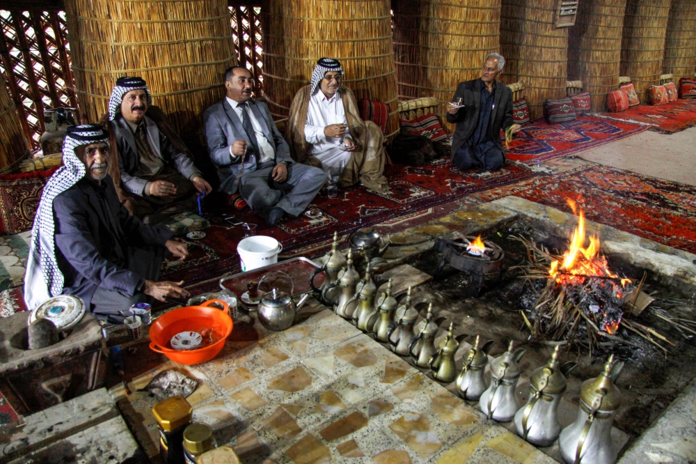 Members of an Iraqi clan gather inside a straw tent in the town of Mishkhab, south of Najaf. For centuries, Iraqi clans have used their own system to resolve disputes, but
authorities are currently classifying it as a 