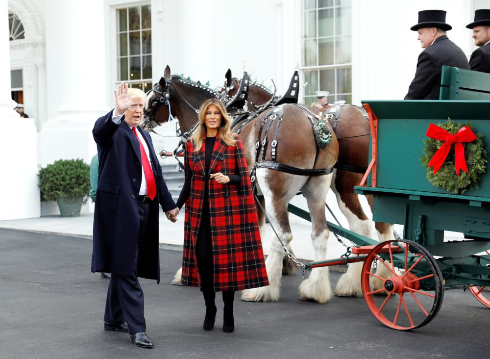 


US President Donald Trump and first lady Melania Trump receive the official White House Christmas tree at the North Portico of the White House in Washington on Monday. — Reuters