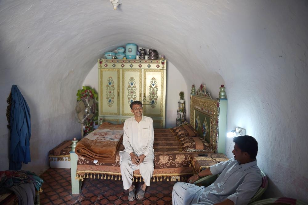 Pakistani villager Ameer Ullah Khan, left, chats with a friend in his cave room in Nikko village, about 60 km from the capital Islamabad, near  the highway town Hasan Abdal in this Oct. 6, 2018 file photo. — AFP