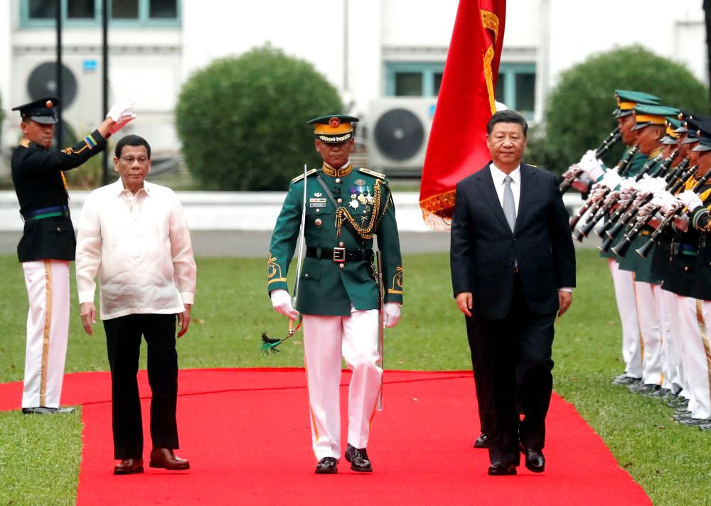 


Visiting Chinese President Xi Jinping, right, and Philippine President Rodrigo Duterte review troops during a welcoming ceremony for the Chinese leader at the Malacanang presidential palace in Manila on Tuesday. — Reuters