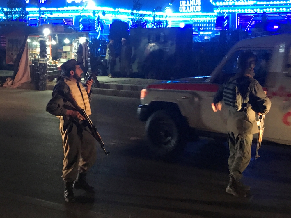 Afghan policeman keep watch at the site of a suicide attack in Kabul on Tuesday. — Reuters