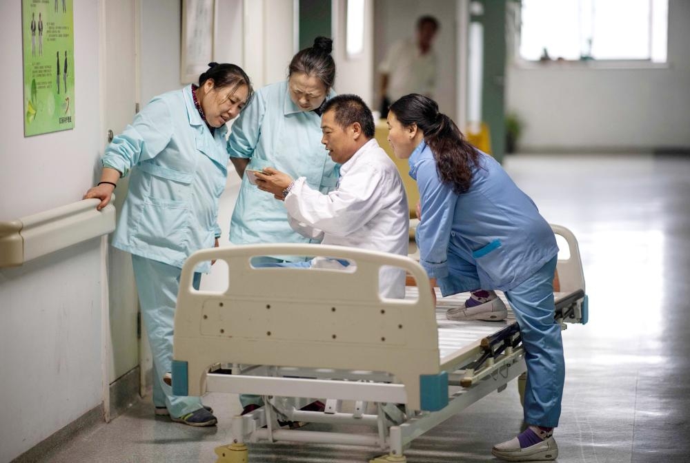 People queue up for medicine in the pharmacy of the Yueyang Hospital, part of the Shanghai University of Traditional Chinese Medicine, in Shanghai, in this Nov. 7, 2018 file photo. — AFP