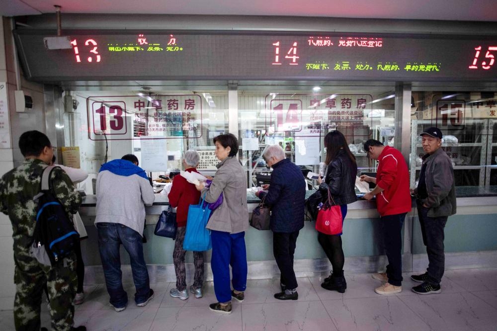 People queue up for medicine in the pharmacy of the Yueyang Hospital, part of the Shanghai University of Traditional Chinese Medicine, in Shanghai, in this Nov. 7, 2018 file photo. — AFP