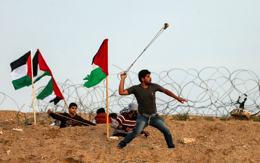 A Palestinian man uses a slingshot to throw stones towards Israeli forces during a protest, east of Gaza City near the Israeli border, in this Nov. 16, 2018 file photo. — AFP