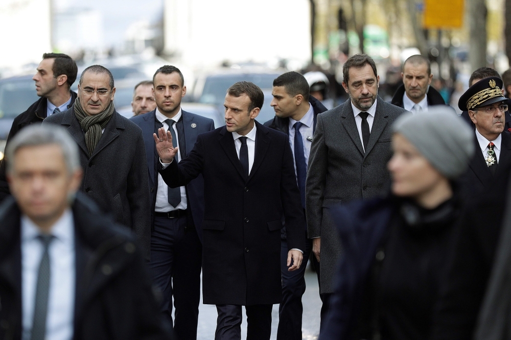 French President Emmanuel Macron (C) flanked by Interior Minister Christophe Castaner (2ndR), Paris police prefect Michel Delpuech (R) and French Junior Minister attached to the Interior Ministry Laurent Nunez (L) walks in a street of Paris on Sunday. — AFP