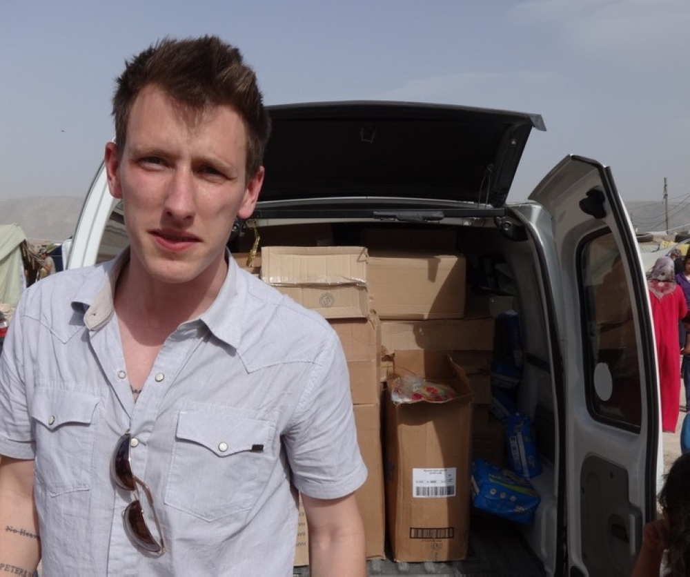 A file handout photo released by the Kassig Family on Oct. 4, 2014, shows Peter Kassig with a truck, taken somewhere along the Syrian border between late 2012 and fall 2013, as Speical Emergency Response and Assistance (SERA) was delivering supplies to refugees.  — AFP