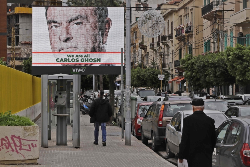 A portrait of ousted Nissan chairman Carlos Ghosn is seen on a publicity billboard in his support at a street in Beirut on Thursday. Ghosn, born in Brazil of Lebanese descent, was arrested in Tokyo over alleged financial misconduct. He is facing further accusation of under-reporting his salary by about $35.5 million over the last three years. — AFP