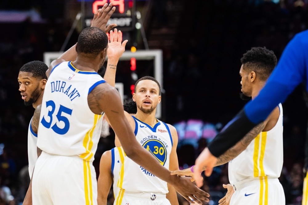 Kevin Durant No. 35 celebrates with Stephen Curry No. 30 of the Golden State Warriors during the second half against the Cleveland Cavaliers at Quicken Loans Arena on Wednesday in Cleveland, Ohio. The Warriors defeated the Cavaliers 129-105. — AFP