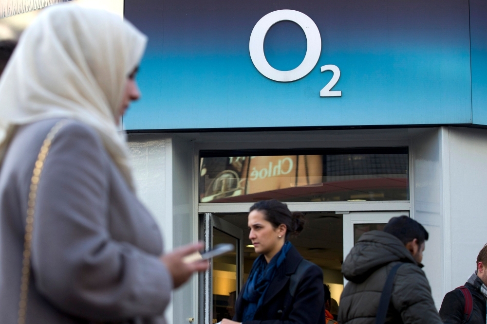 In this file photo, people walk past a branch of an O2 store in central London.  Britain's Spanish-owned mobile phone operator O2 and Japan's SoftBank said Thursday that millions of customers were unable to use data due to a glitch. — AFP