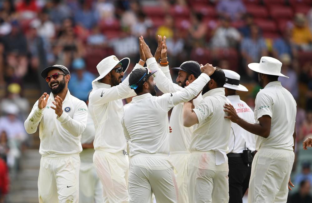 India’s captain Virat Kohli (L) reacts with teammates after the dismissal of Australia’s Peter Handscomb on day four of the first Test match at the Adelaide Oval Sunday. — AFP