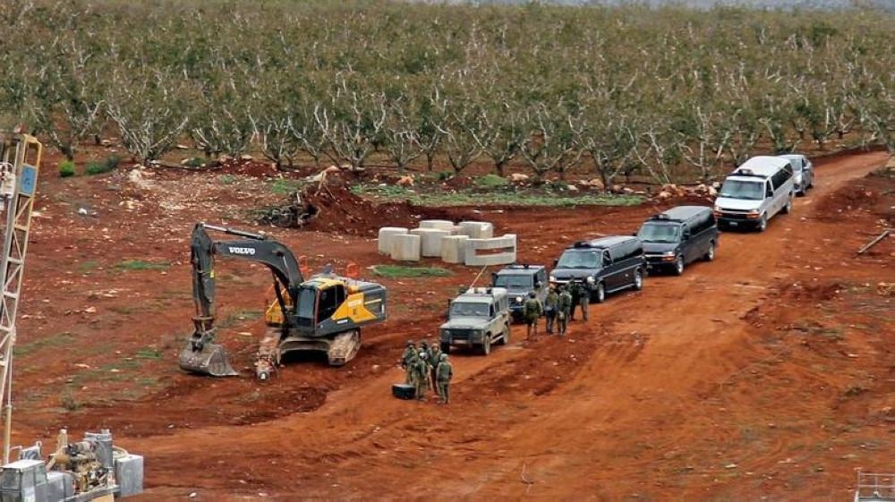 A picture taken on Dec. 5, 2018 near the southern Lebanese village of Kfar Kila shows members of the Israeli military, excavators and trailers operating on the other side of the border. — AFP
