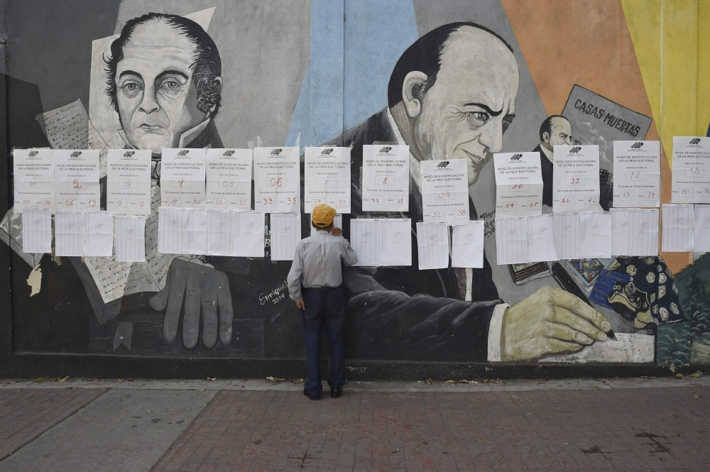 A voter looks for his name at a polling station in Caracas during Venezuelan municipal council elections on Sunday. — AFP
