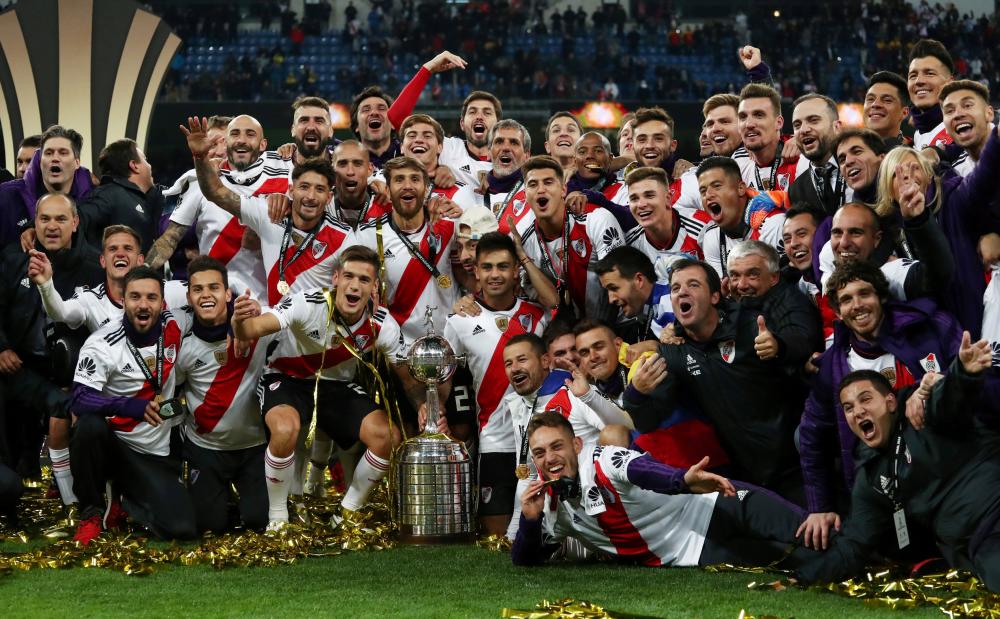 River Plate players celebrate with the trophy after winning the Copa Libertadores final against Boca Juniors at Santiago Bernabeu Stadium in Madrid Sunday. — Reuters 