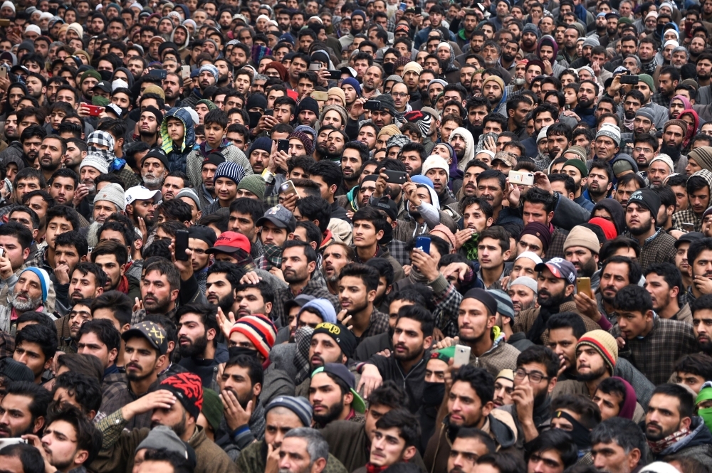 Kashmiri villagers look on during the funeral procession of slain teenager militant Mudasir Ahmad Parrey, 14, in Hajin, north of Srinagar, on Monday. — AFP