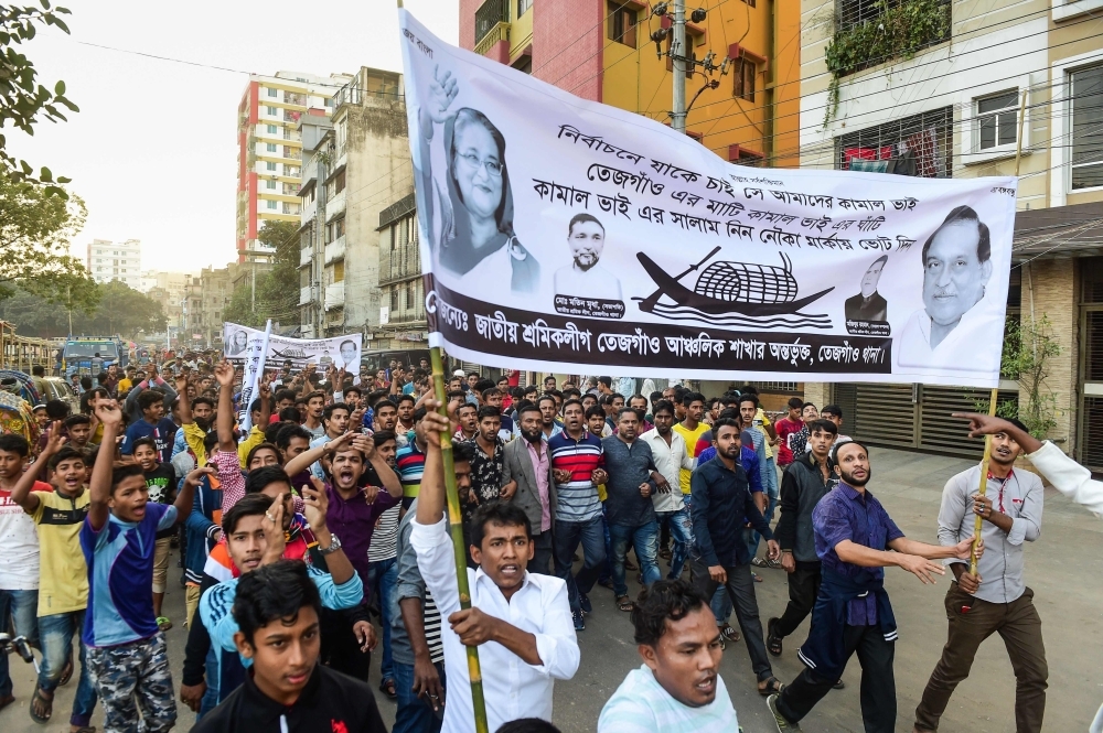 Supporters of Bangladesh Awami League march in the street as they take part in a general election campaign procession in Dhaka on Monday. — AFP