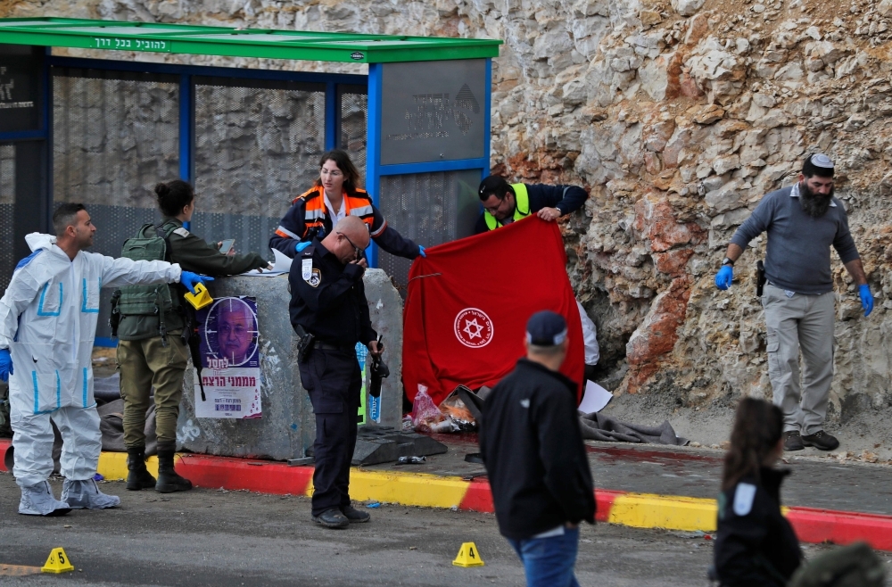 Israeli forces and forensic experts inspect the site of a Palestinian drive-by shooting attack outside the West Bank settlement of Givat Asaf, northeast of Ramallah, on Thursday. — AFP