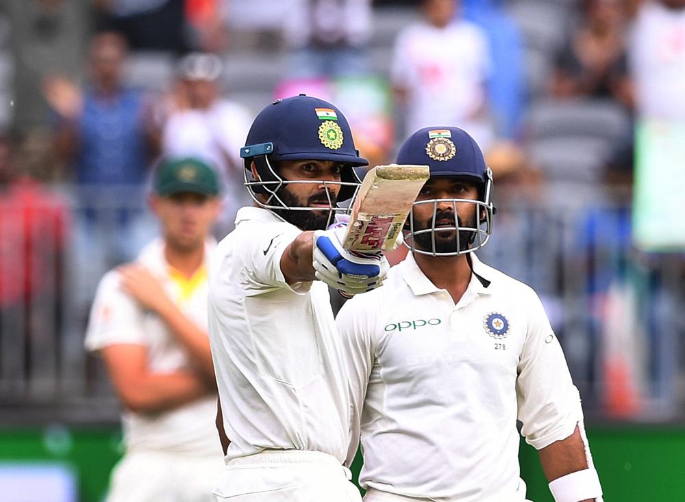 India’s captain Virat Kohli raises his bat after scoring a half century on day two of the second Test match against Australia at Perth Stadium in Perth Saturday. — Reuters