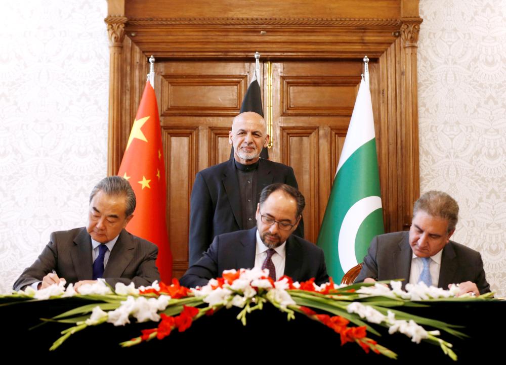 Afghanistan's Foreign Minister Salahuddin Rabbani (sitting-center), Pakistan's Foreign Minister Shah Mehmood Qureshi and Chinese Foreign Minister Wang Yi sign a memorandum of understanding on cooperation in fighting terrorism in Kabul, Afghanistan, Saturday. — Reuters
