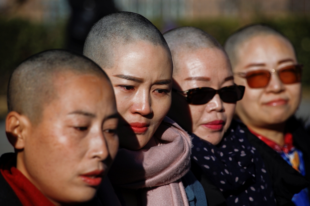  Yuan Shanshan, Li Wenzu, Liu Ermin, Wang Qiaoling, wives of prominent Chinese rights lawyers, pose for pictures after shaving their heads in protest over the government’s treatment of their husbands in Beijing, China, on Monday. — Reuters 