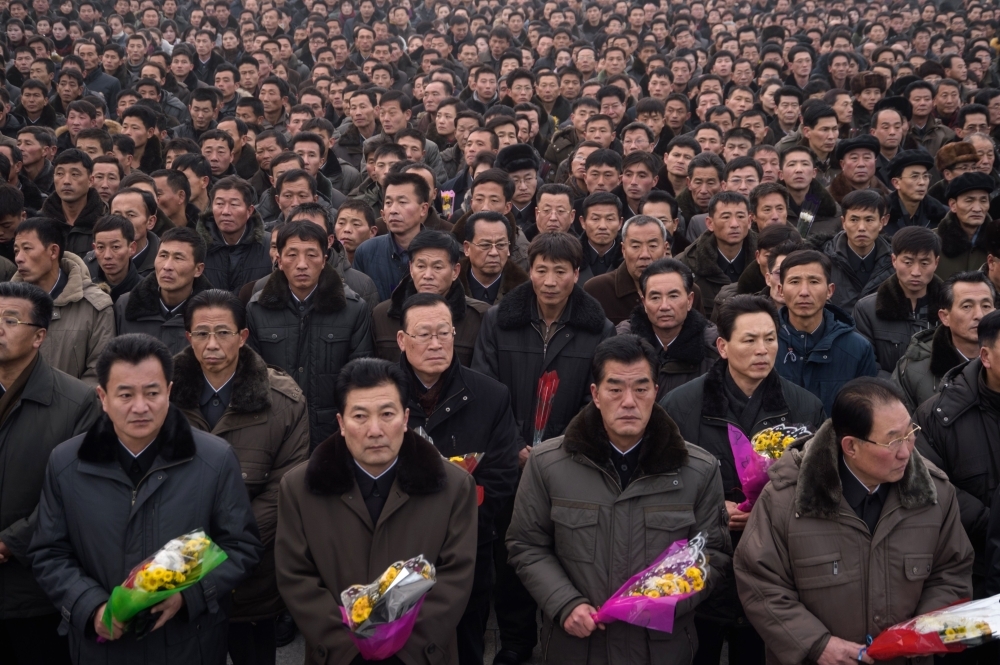 Pyongyang residents prepare to lay flowers at the statues of late North Korean leaders Kim Il Sung and Kim Jong Il during National Memorial Day on Mansu Hill in Pyongyang on Monday. — AFP