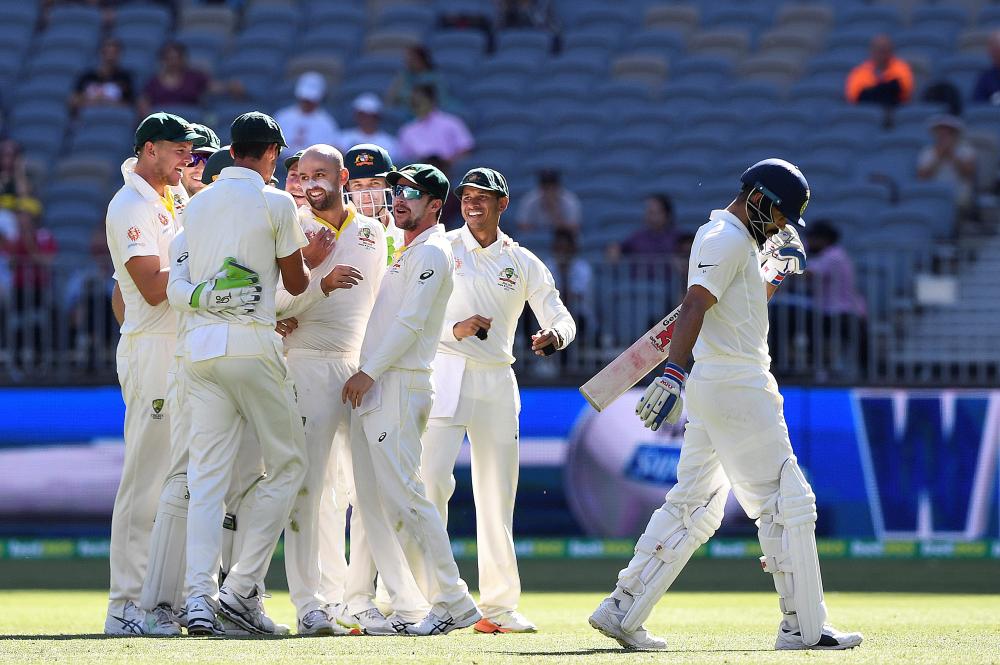 Australia’s players celebrate the dismissal of India’s captain Virat Kohli (R) on day four of the second Test match at Perth Stadium Monday. — Reuters