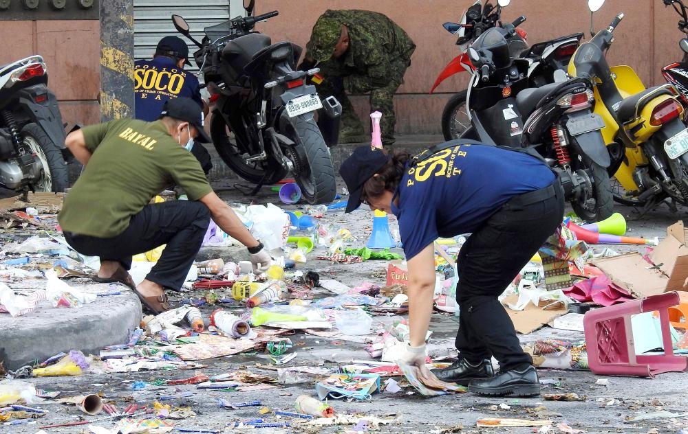 Police officers investigate at the site of an explosion outside a shopping mall in Cotabato City on the southern island of Mindanao on Monday. — AFP