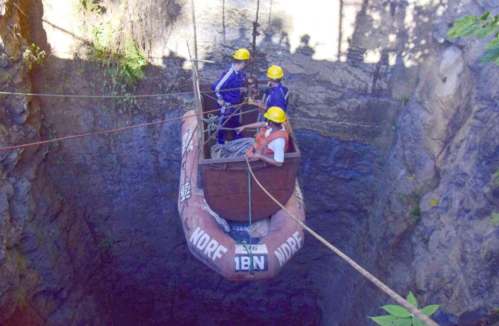 In this photo taken on Sunda, Indian Navy divers go down in the mine with a pulley during rescue operations after 15 miners were trapped by flooding in an illegal coal mine in Ksan village in Meghalaya’s East Jaintia Hills district of India. — AFP