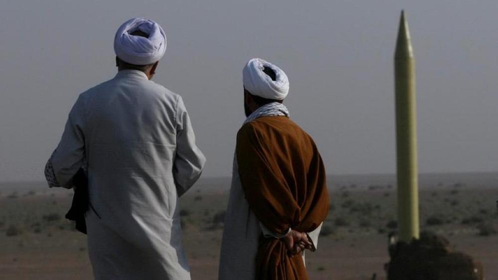 Two Iranian clerics stand near a surface-to-surface missile, which is ready to launch during a war game near the city of Qom in this file photo. — Reuters