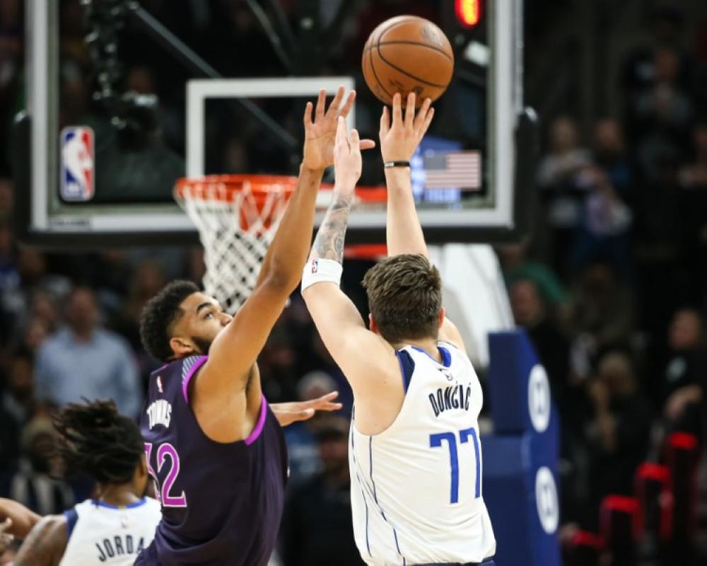 Rookie sensation Luka Doncic of Dallas Mavericks shoots over Karl-Anthony Towns of Minnesota Timberwolves during their NBA game in Menneapolis Friday. — Reuters