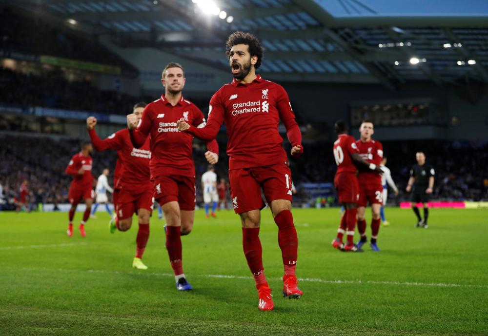 Liverpool's Mohamed Salah celebrates scoring their only goal with Jordan Henderson against Brighton & Hove Albion during their Premier League match at the American Express Community Stadium, Brighton, Saturday. — Reuters
