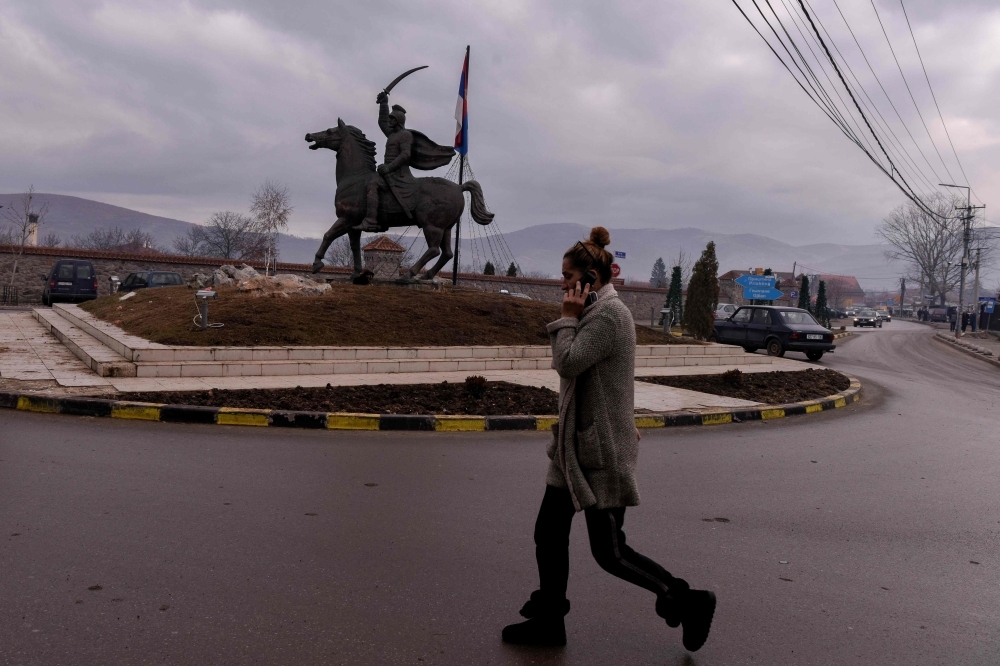 A Kosovo Serb woman walks past a statue in the town of Gracanica near Pristina. Dispersed in small enclaves like Gracanica throughout the country, Kosovo Serbs consider dangerous the idea to change borders with Serbia which has been discussed between Pristina and Belgrade as part of a historical peace agreement. — AFP 