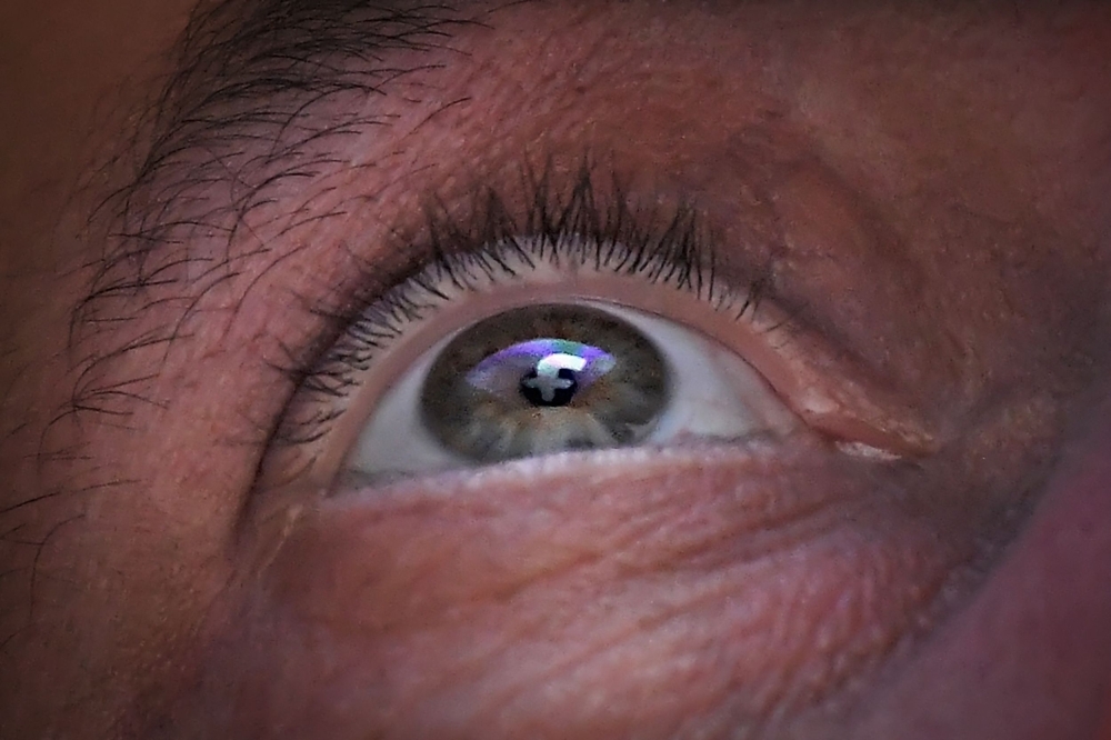The logo of social network Facebook is seen on the eye of a man in Nantes, western France, on Tuesday. — AFP