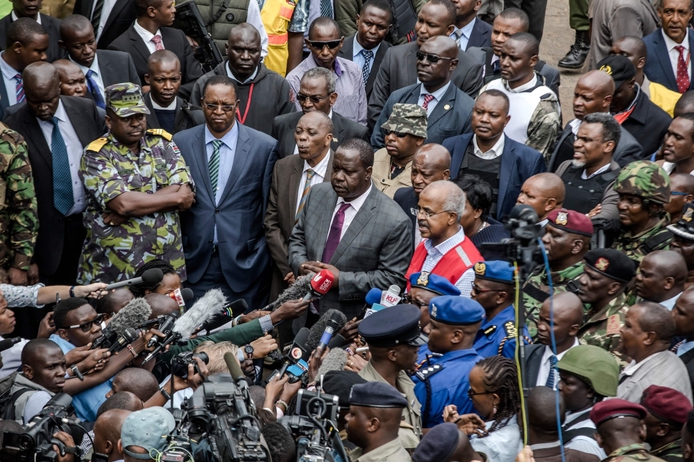 Kenyan Cabinet Secretary for Internal Security Fred Okengo Matiang’i, center, speaks to the press upon his arrival on the scene of the terrorist attack at the hotel complex in Nairobi’s Westlands suburb in Kenya on Wednesday. — AFP