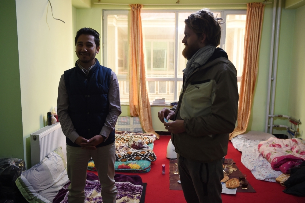 Afghan couch-surfing host Naser Majidi, left, 27, talks with Norwegian tourist Jorn Bjorn Augestad, 29, at a house in Kabul in this Nov. 11, 2018 file photo. — AFP