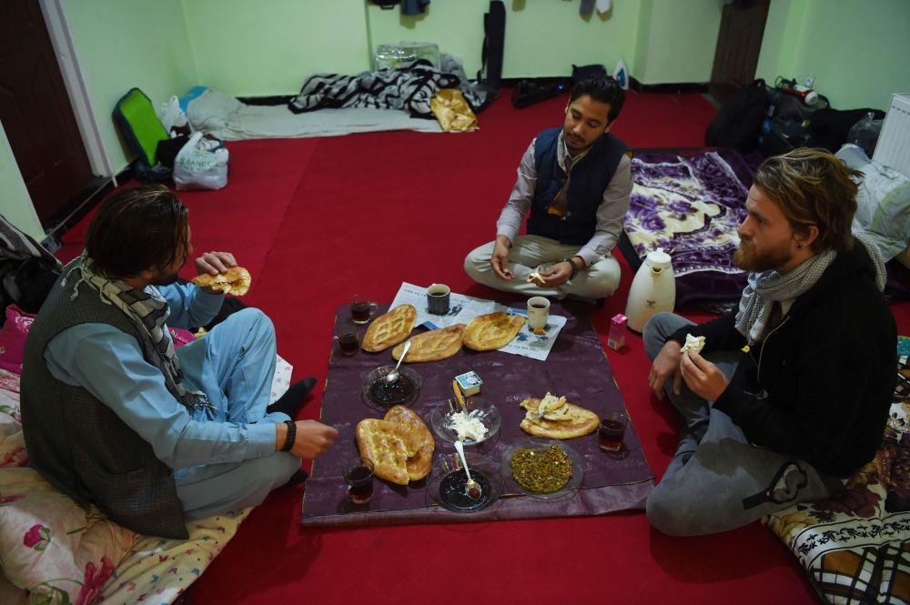 Afghan couch-surfing host Naser Majidi, left, 27, talks with Norwegian tourist Jorn Bjorn Augestad, 29, at a house in Kabul in this Nov. 11, 2018 file photo. — AFP