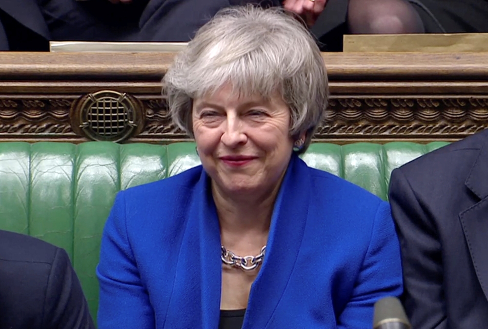 British Prime Minister Theresa May reacts as Jeremy Corbyn speaks, after she won a confidence vote, after Parliament rejected her Brexit deal, in London, Britain, on Wednesday, in this screen grab taken from video. — Reuters