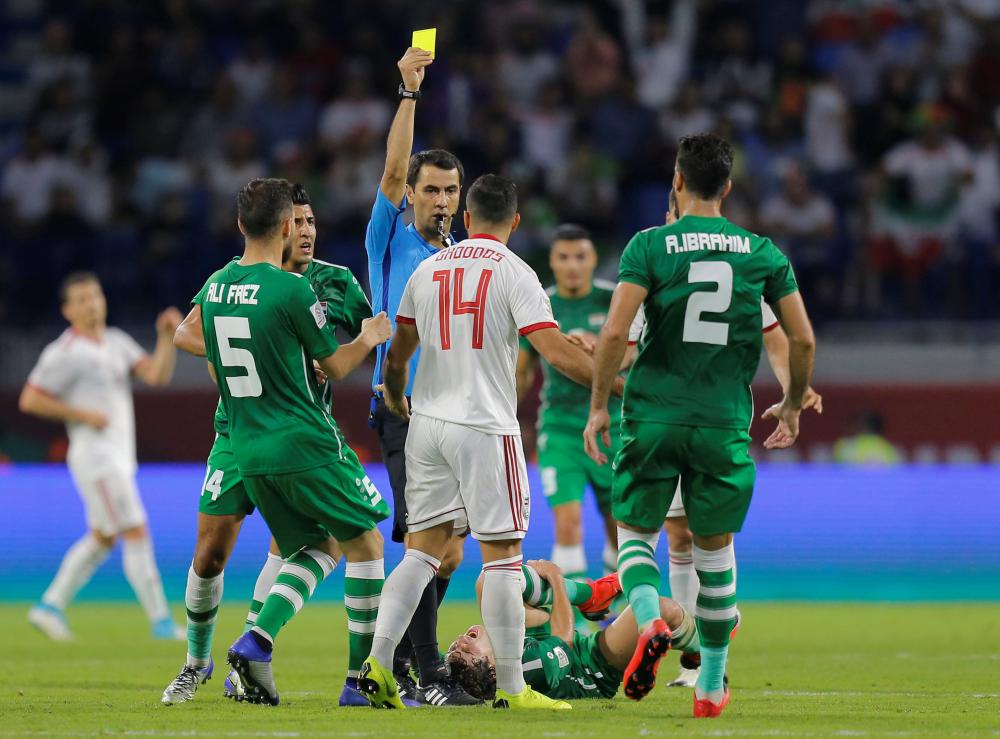 Iran's Saman Ghoddos is shown a yellow card by referee Ravshan Irmatov during their Asian Cup match against Iraq at Al-Maktoum Stadium in Dubai Wednesday. — Reuters
