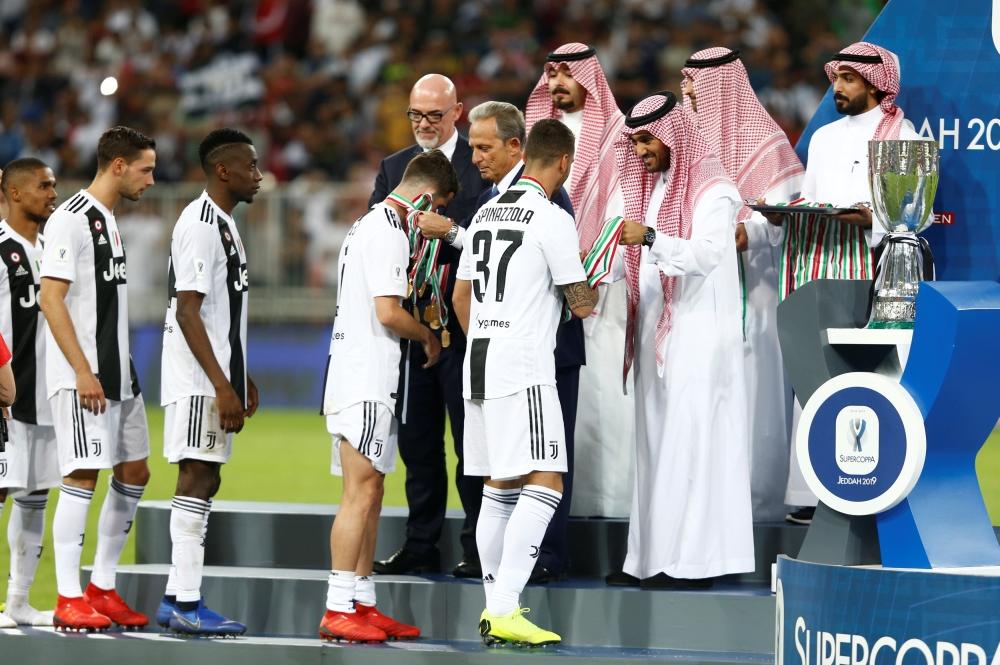 Juventus' Italian defender Giorgio Chiellini lifts the Supercoppa Italiana after winning the final against AC Milan at the King Abdullah Sports City Stadium in Jeddah Wednesday. — AFP 