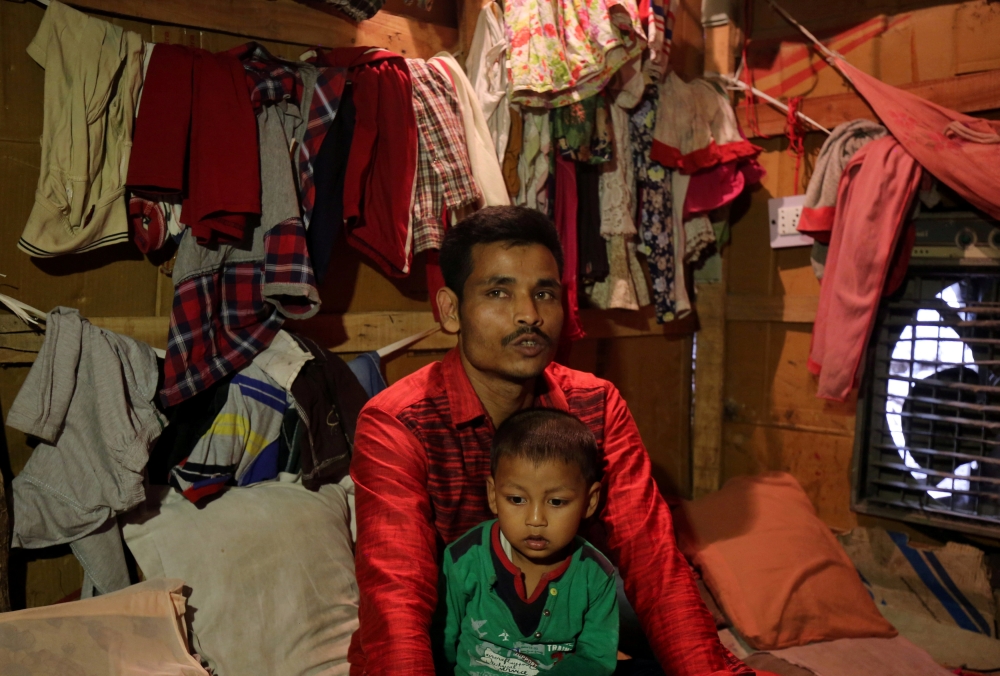 Sahidullah, a man from the Rohingya community, holds his son on his lap as he speaks with Reuters inside his shack at a camp on the outskirts of Jammu in this Oct. 5, 2018 file photo. — Reuters