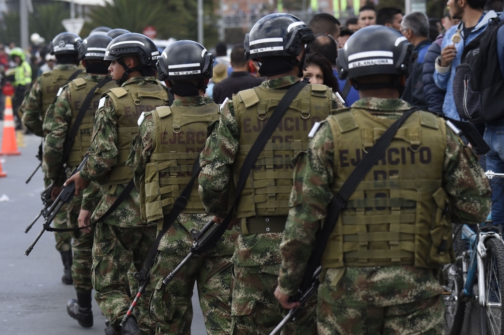 Members of the security forces patrol around the site of an explosion on a police cadet training school in Bogota on Thursday. — AFP