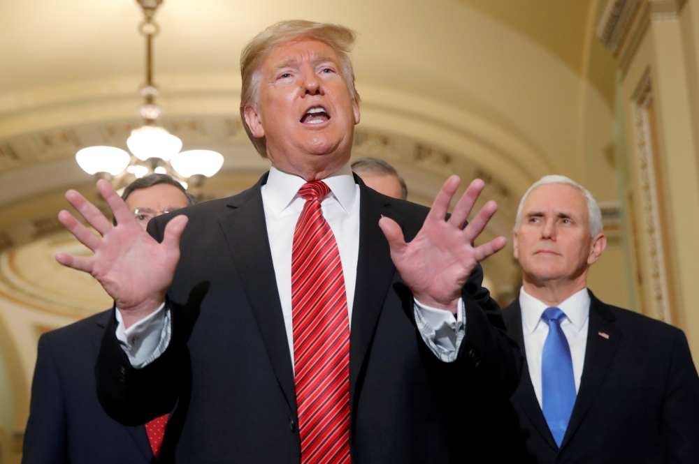 US President Donald Trump talks to reporters as Vice President Mike Pence looks on as the president departs after addressing a closed Senate Republican policy lunch while a partial government shutdown enters its 19th day on Capitol Hill in Washington in this Jan. 9, 2019 file photo. — Reuters