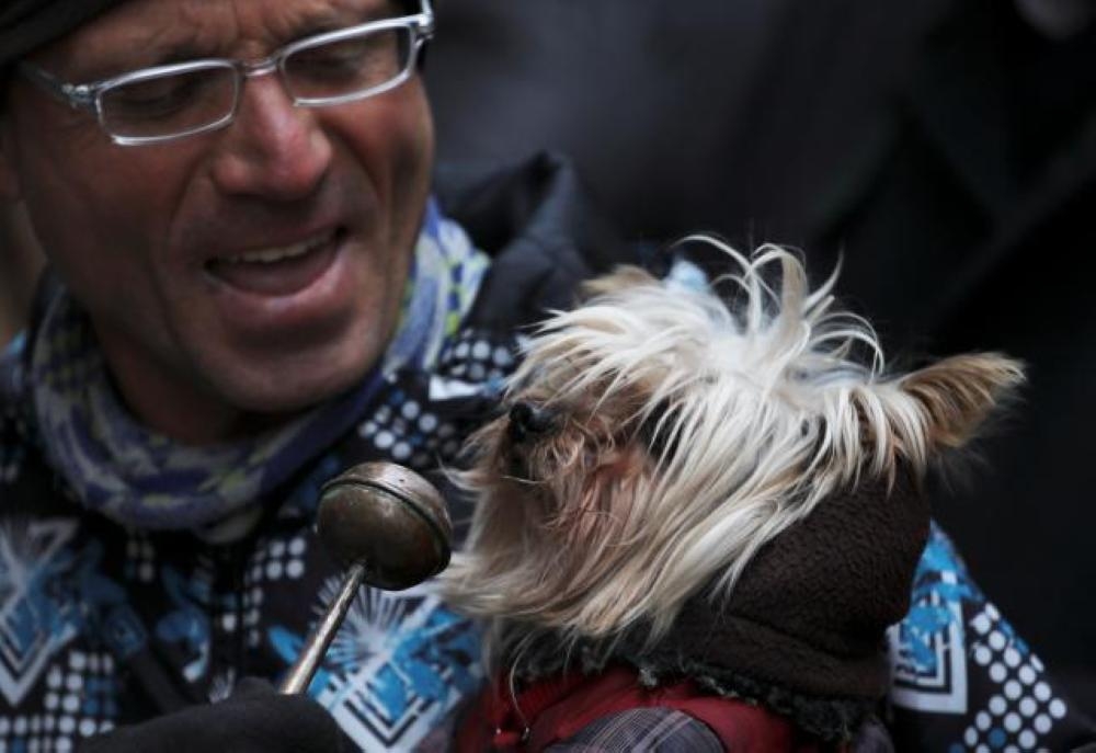 A dog owner brings his pet to a Madrid curch to be blessed. — Reuters