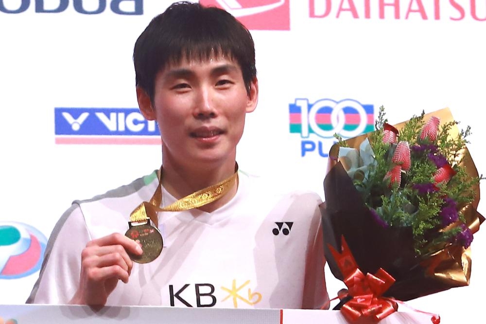 Son Wan-ho of South Korea poses with his gold medal on the podium after winning the final against Chen Long of China at the Malaysia Masters Badminton Tournament in Kuala Lumpur Sunday. — AFP