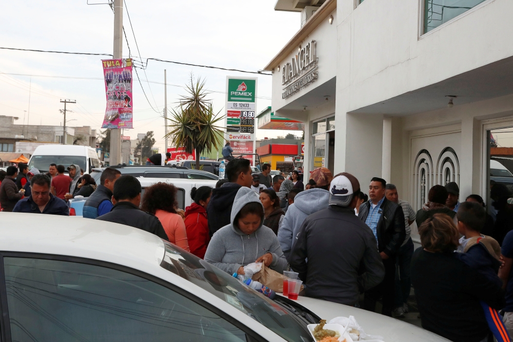 Residents outside a funeral parlor wait for news of their relatives missing during the explosion of a fuel pipeline ruptured by suspected oil thieves, in Tula, Mexico. — Reuters