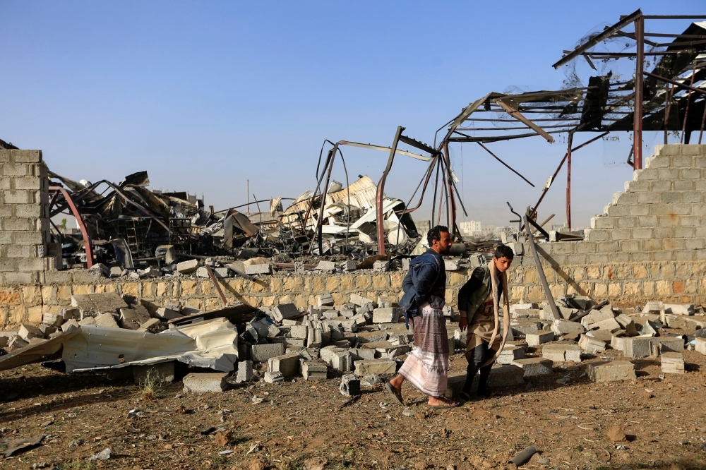 Civilians inspect the damage at a factory after a reported airstrike by Saudi-led coalition in the Yemeni capital Sanaa, on Sunday. — AFP